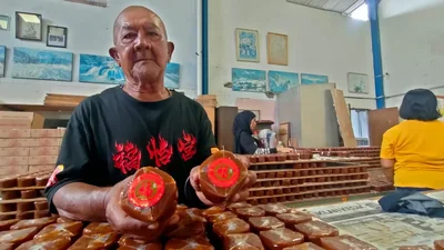 Salah satu pekerja menunjukkan kue keranjang Sido Makmur rasa original yang diproses selama kurang lebih 12 jam, Senin 12 Januari 2026.