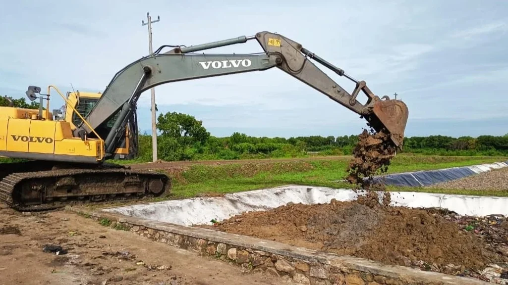 Sebuah alat berat dikerahkan untuk menimbun tanah pada timbulan residu sampah di salah satu cell TPA Bokong Semar. Foto : Dok DLH Kota Tegal