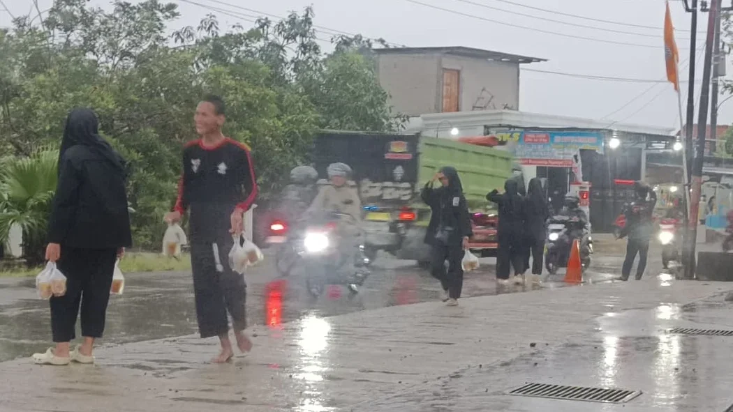 Ditengah Guyuran Hujan, Korlap PSHT Bahurekso Kendal Semangat Membagikan Takjil