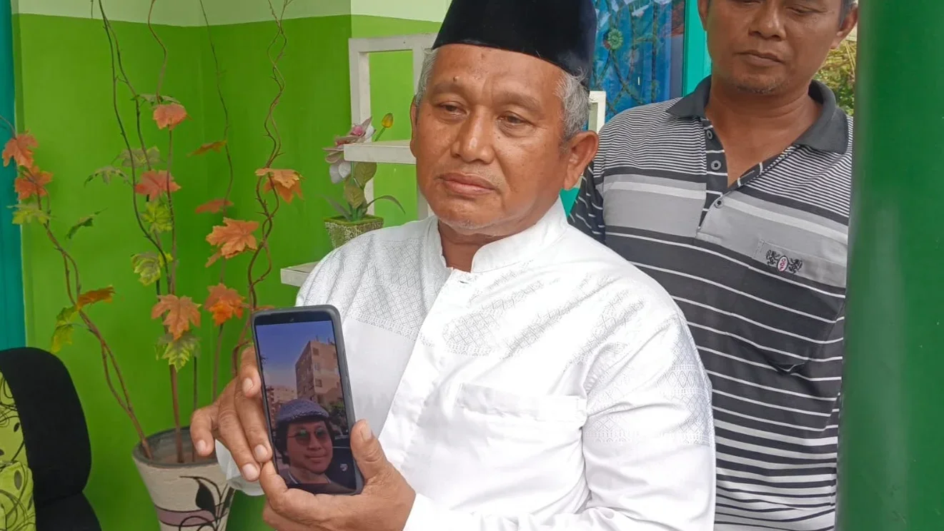 Ayah korban, Abdul Basit, menunjukkan foto putranya Muhamad Ashim Alfabirri yang meninggal terseret arus dan ombak di Laut Tengah, Mesir.