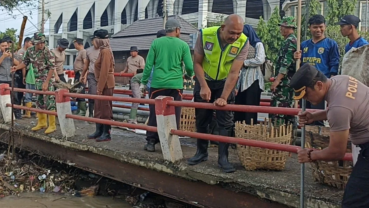 Aksi bersih-bersih sampah yang menyumbat di jembatan sungai Kendal. edhot