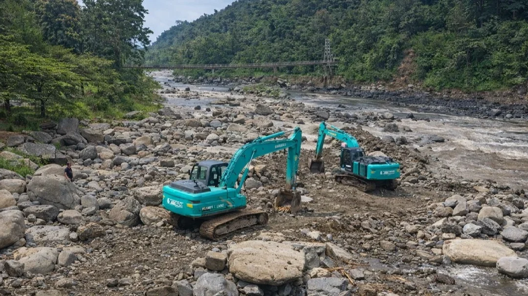 Alat berat mengeruk material sisa banjir besar di Sungai Gung yang mengakibatkan kerusakan jembatan gantung Sangkanjaya, Kecamatan Balapulang, Kabupaten Tegal, Senin 30 Maret 2026. (Dok)