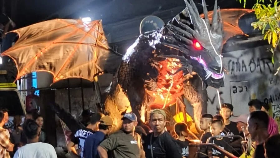 Sebuah patung naga memeriahkan tradisi takbir keliling di Dukuh Banjaranyar, Desa Harjasari, Kecamatan Suradadi, Kabupaten Tegal, Jumat malam 20 Maret 2026.