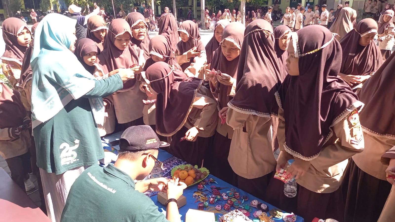 Siswa MI Luqman Al Hakim Slawi mengikuti belajar mengolah sampah bungkus kopi dan botol bekas menjadi gantungan kunci dan mainan. Kegiatan tersebut bagian dari acara peluncuran program Samtaku atau Sampahku Tanggung Jawabku yang dilaksanakan Jumat, 24 April 2026 di halaman sekolah. 