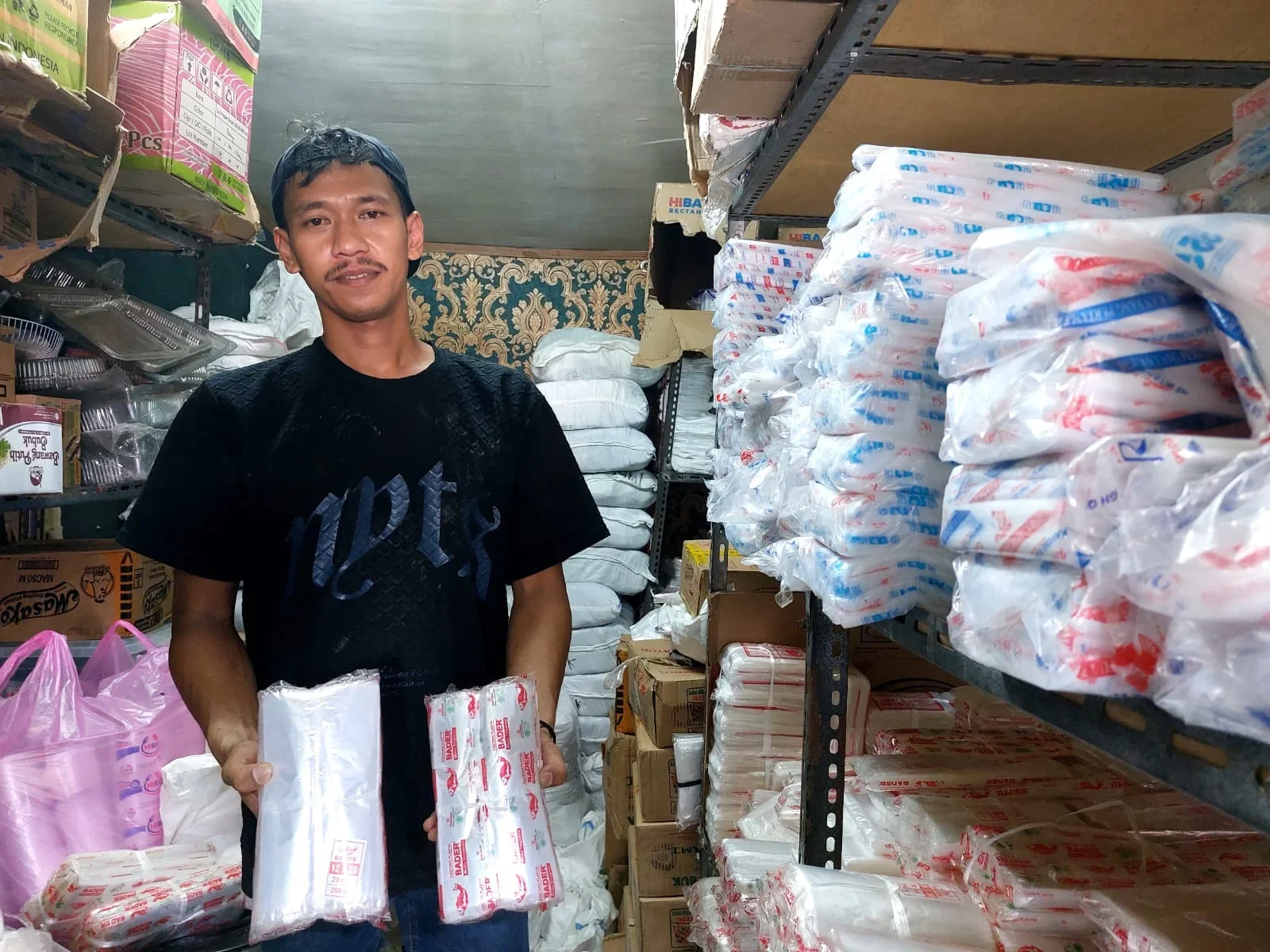 Pedagang plastik di Pasar Pagi Pemalang menunjukan plastik wadah bening yang harganya melonjak tajam/PUSKAPIK/ERIKO 