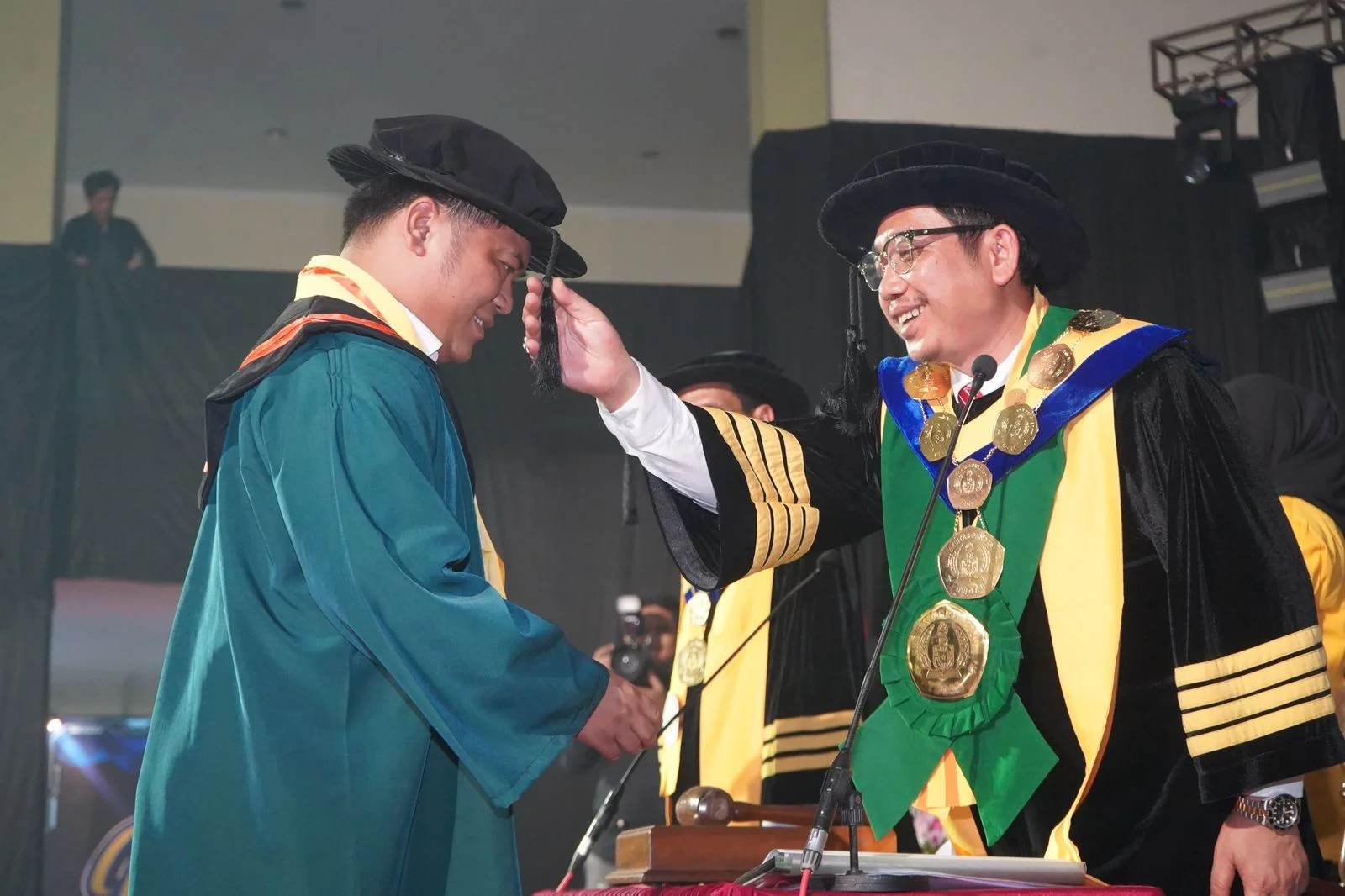 Rektor UPS Tegal, Prof Dr Taufiqulloh memindahkan tali toga Bupati Tegal, H Ischak Maulana Rohman saat wisuda di UPS Tegal, Sabtu 11 April 2026. (Dok) 