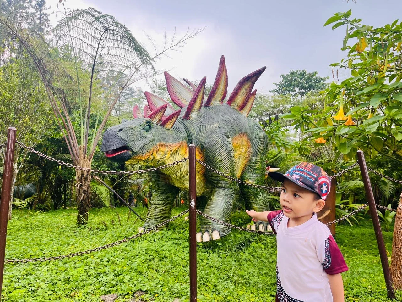 Seorang pengunjung menikmati patung dinasaurus di Dino Land  D'Las di Kecamatan Karangreja, Kabupaten Purbalingga, Sabtu 18 April 2026. (Guntur) 