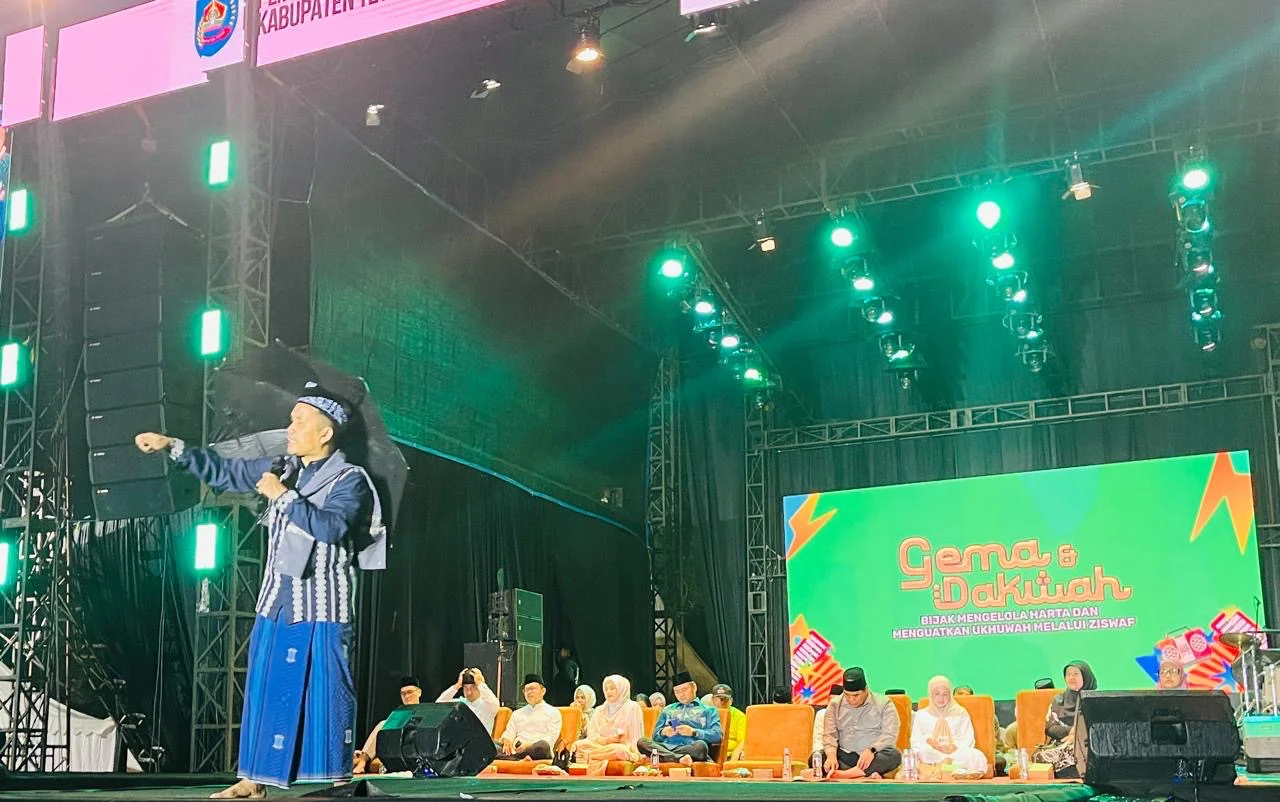 Ustad Maulana pakai payung saat ceramah di acara Gema Dakwah dalam rangka Hari Jadi ke-425 Kabupaten Tegal di lapangan Pemkab Tegal, Jumat malam 22 Mei 2026. (Guntur)