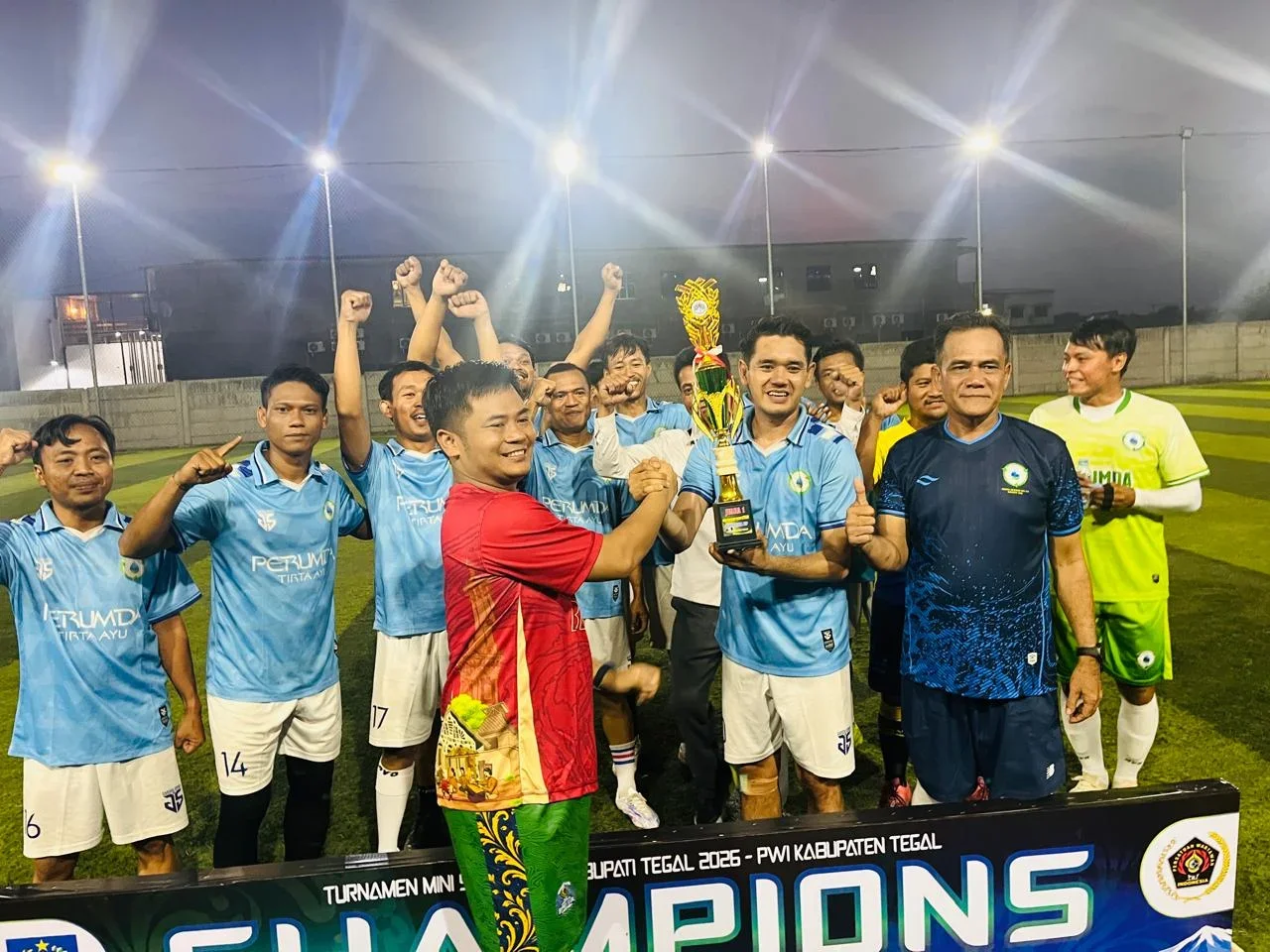 Bupati Tegal H Ischak Maulana Rohman menyerahkan piala juara 1 Turnamen Mini Soccer Piala Bupati Tegal 2026 kepada kapten Tim Perumda Tirta Ayu Slawi di lapangan mini soccer Buah Naga Trayeman Slawi, Rabu 3 Juni 2026. (Guntur) 