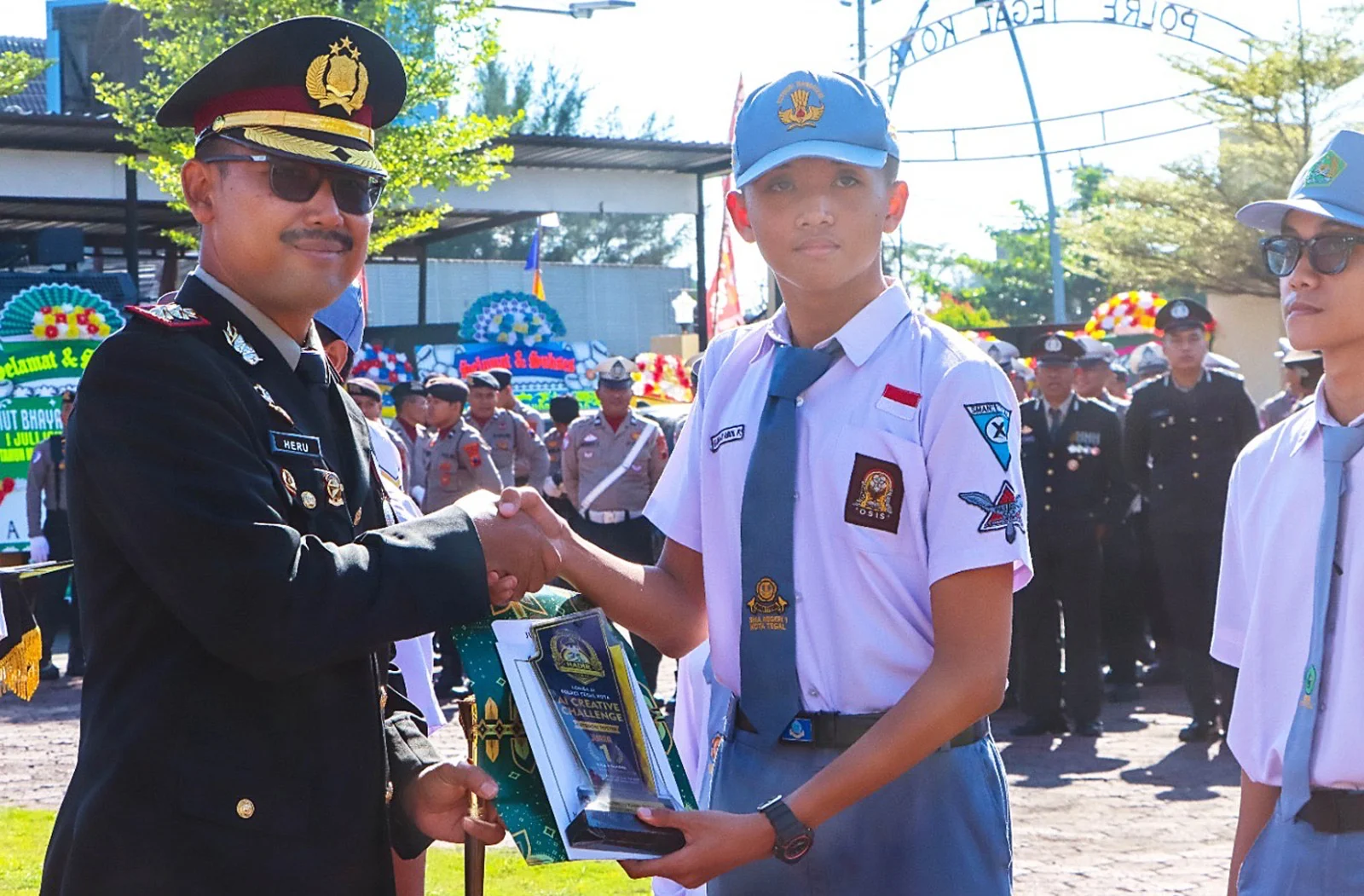 Muhamad Repa Hafidz Mulyana yang meraih Juara Pertama Lomba Konten Kreatif Video AI, saat menerima penghargaan dan hadiah dari Kapolres Tegal Kota AKBP Heru Antariksa Cahya SIK MH, di sela-sela Upacara Puncak Peringatan Hari Bhayangkara Ke-80, Rabu (1/7).