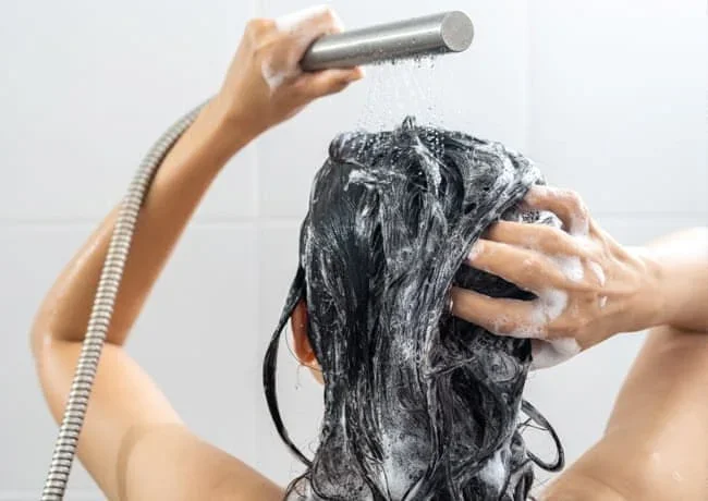 ilustrasi wanita sedang malakukan keramas rambut 