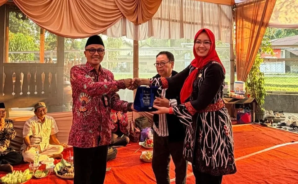 Staf Ahli Menteri Koperasi Bidang Hubungan Antar Lembaga Henny Navilah memberikan cenderamata kepada Kepala Dinas Koperasi, UKM, dan Perdagangan Kabupaten Tegal Imam Rudi Kurnianto saat studi lapangan di Desa Lumingser, Kecamatan Adiwerna Kabupaten Tegal, Minggu 5 Juli 2026. (Dok)