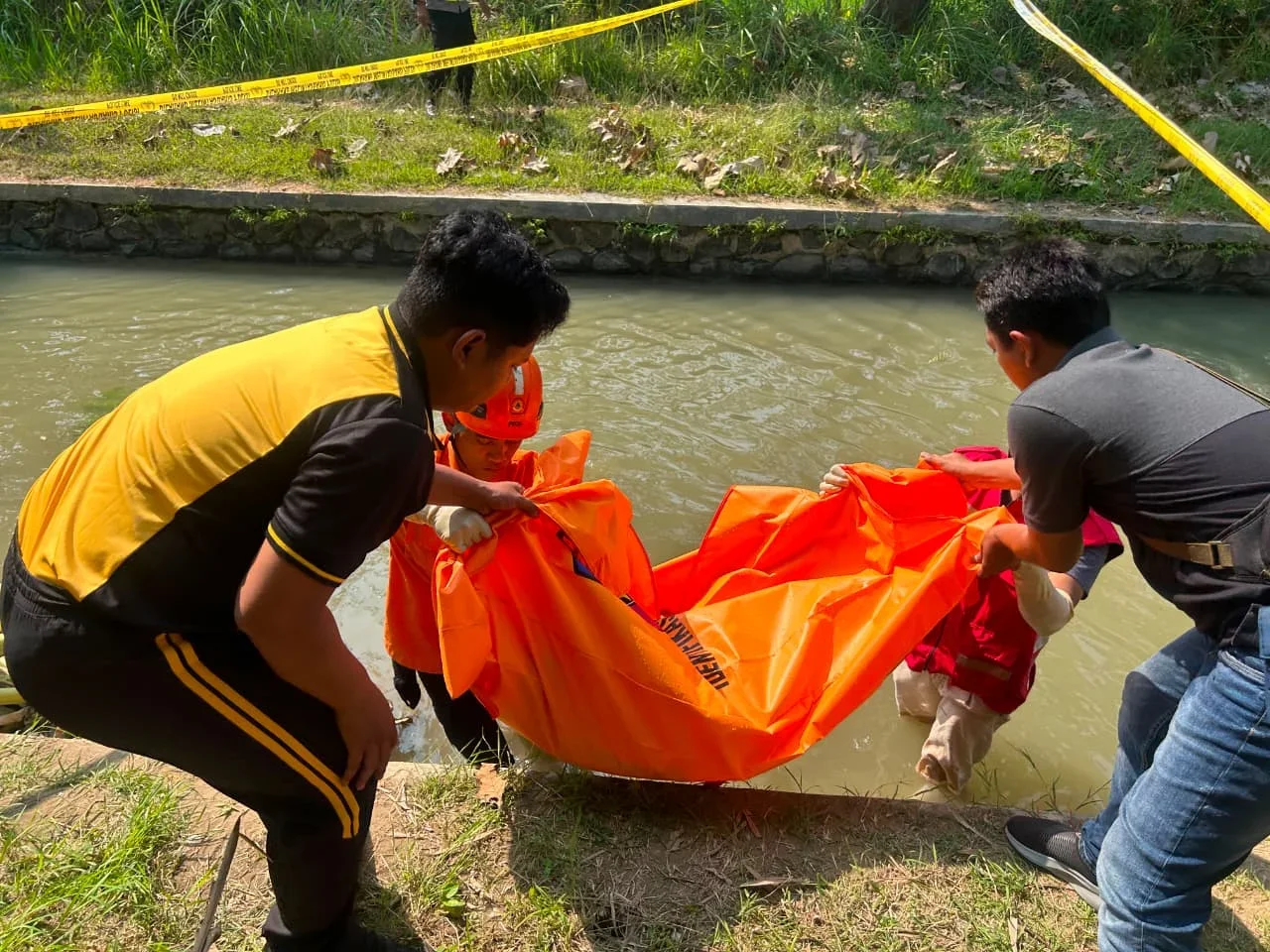 Petugas melakukan evakuasi jenasah perempuan tanpa identitas yang ditemukan di saluran irigasi. (edhot)