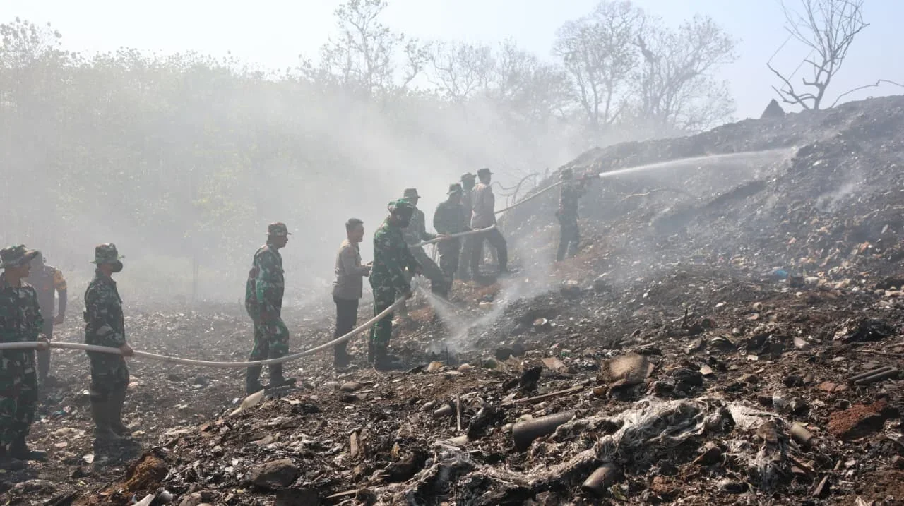 Anggota TNI membantu memadamkan bara di bekas lahan TPA Darupono.