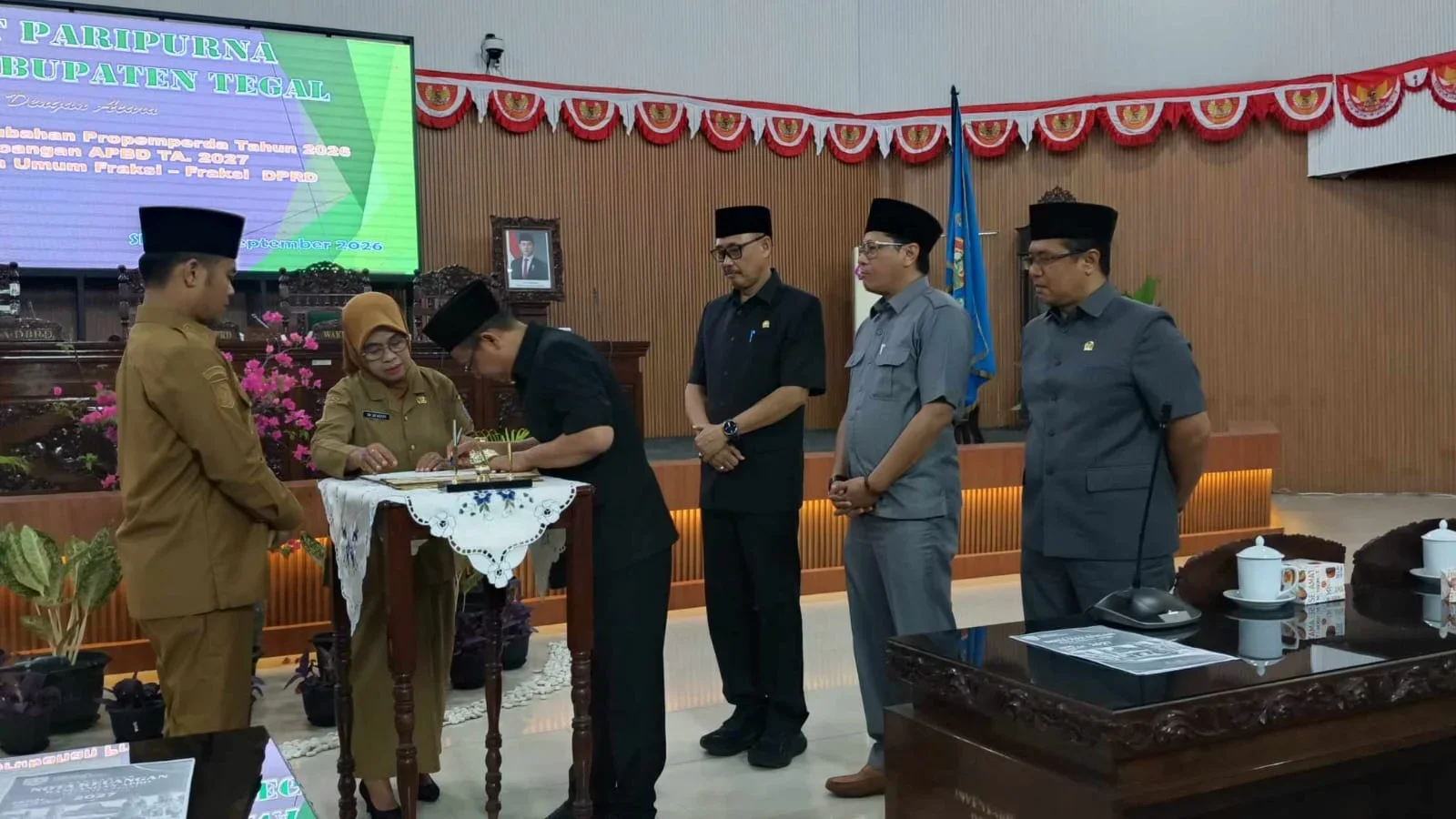 Bupati Tegal, H Ischak Maulana Rohman menyerahkan Rancangan APBD Kabupaten Tegal tahun 2027 ke Ketua DPRD Kabupaten Tegal, H Wasbun Jauhara Khalim saat Rapat Paripurna DPRD Kabupaten Tegal, Senin 28 September 2026. 